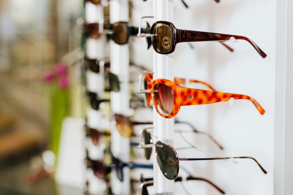 A vibrant assortment of fashionable sunglasses displayed on a store rack, ready for a trendy sale.